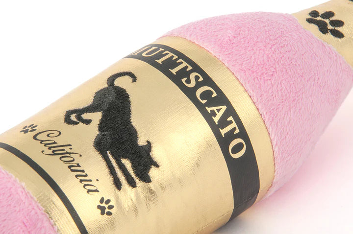 Close-up of champagne bottle dog toy showing soft plush material and design detail