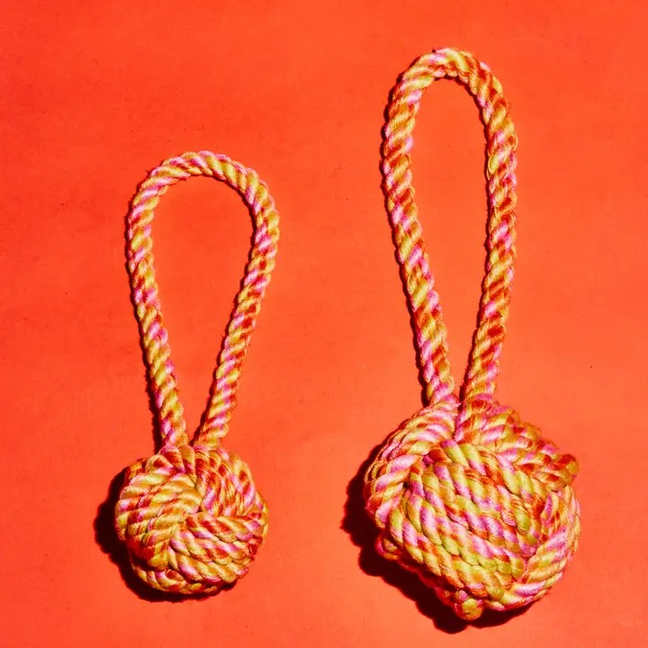 Cotton rope knot dog toy available in small and large sizes for chewing, tug of war, and interactive play.