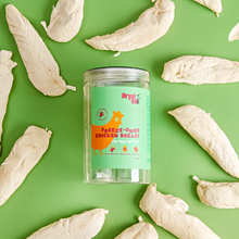 Freeze-dried chicken breast dog treats in a jar from Arya Sit surrounded by single-ingredient chicken pieces