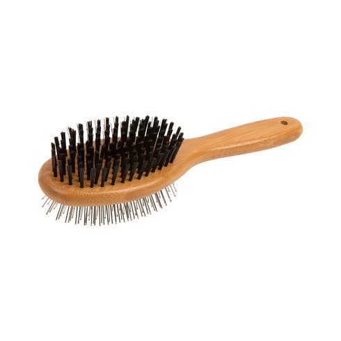 Close-up of bamboo dog grooming brush showing natural bristles and cushioned base