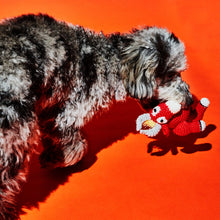 Dog holding an organic cotton bull dog toy made from non-toxic cotton with a squeaker