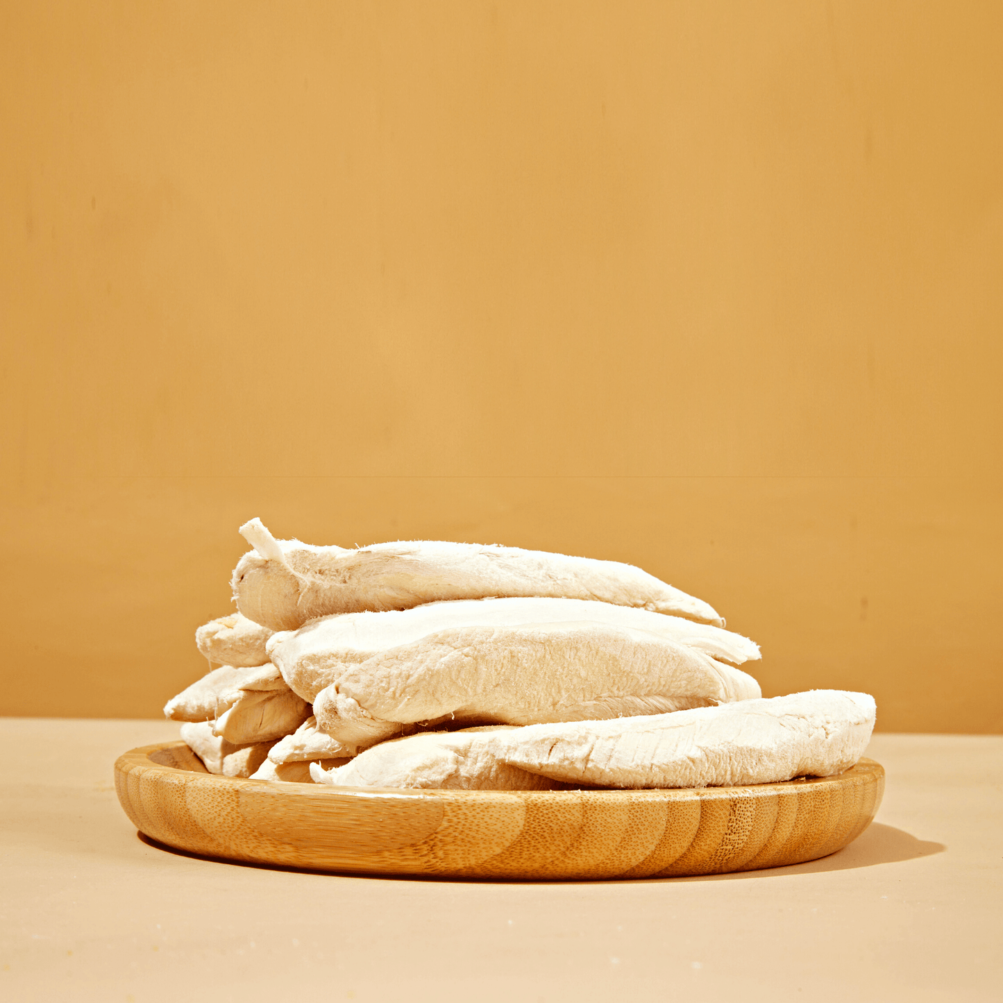 Close-up of freeze-dried chicken breast dog treats stacked on a neutral background