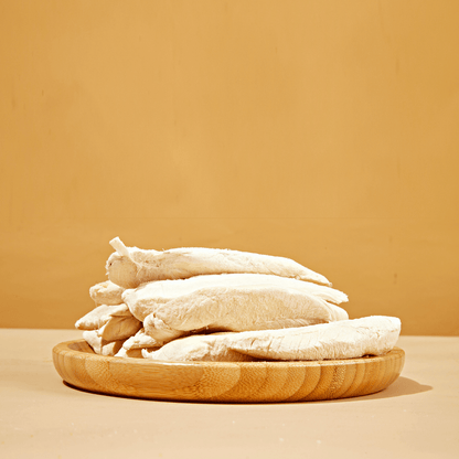 Close-up of freeze-dried chicken breast dog treats stacked on a neutral background