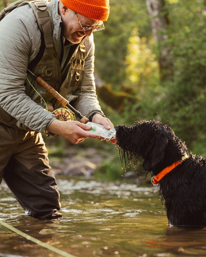 Dog receiving salmon squeeze dog treats during outdoor training and rewarding